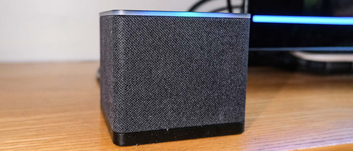 A close-up of the Fire TV Cube (2022) with its blue Alexa bar glowing