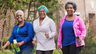 Three senior African American women walking and laughing together