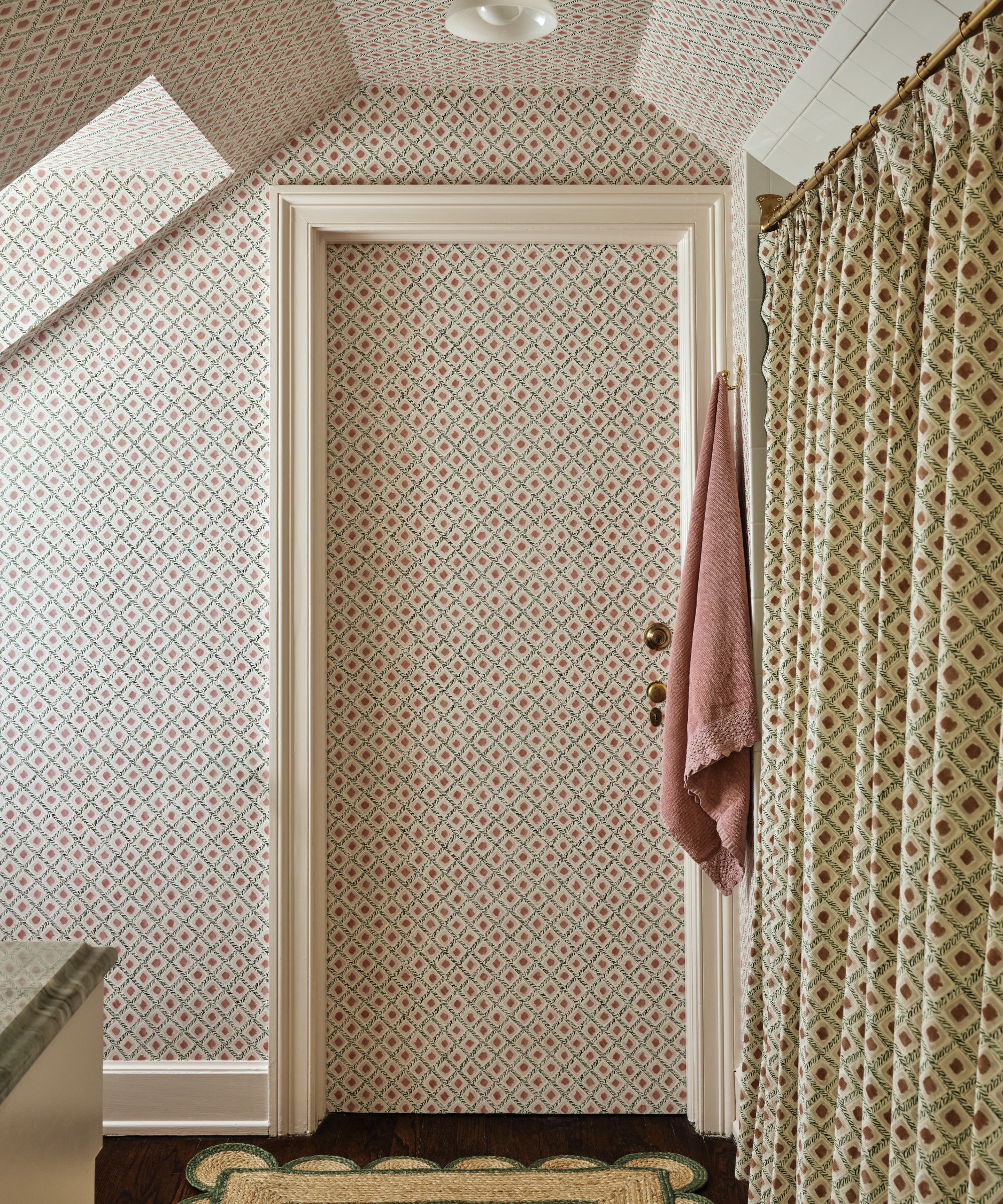 a pink pattern drenched guest bathroom with patterned shower curtain and wallpapered walls