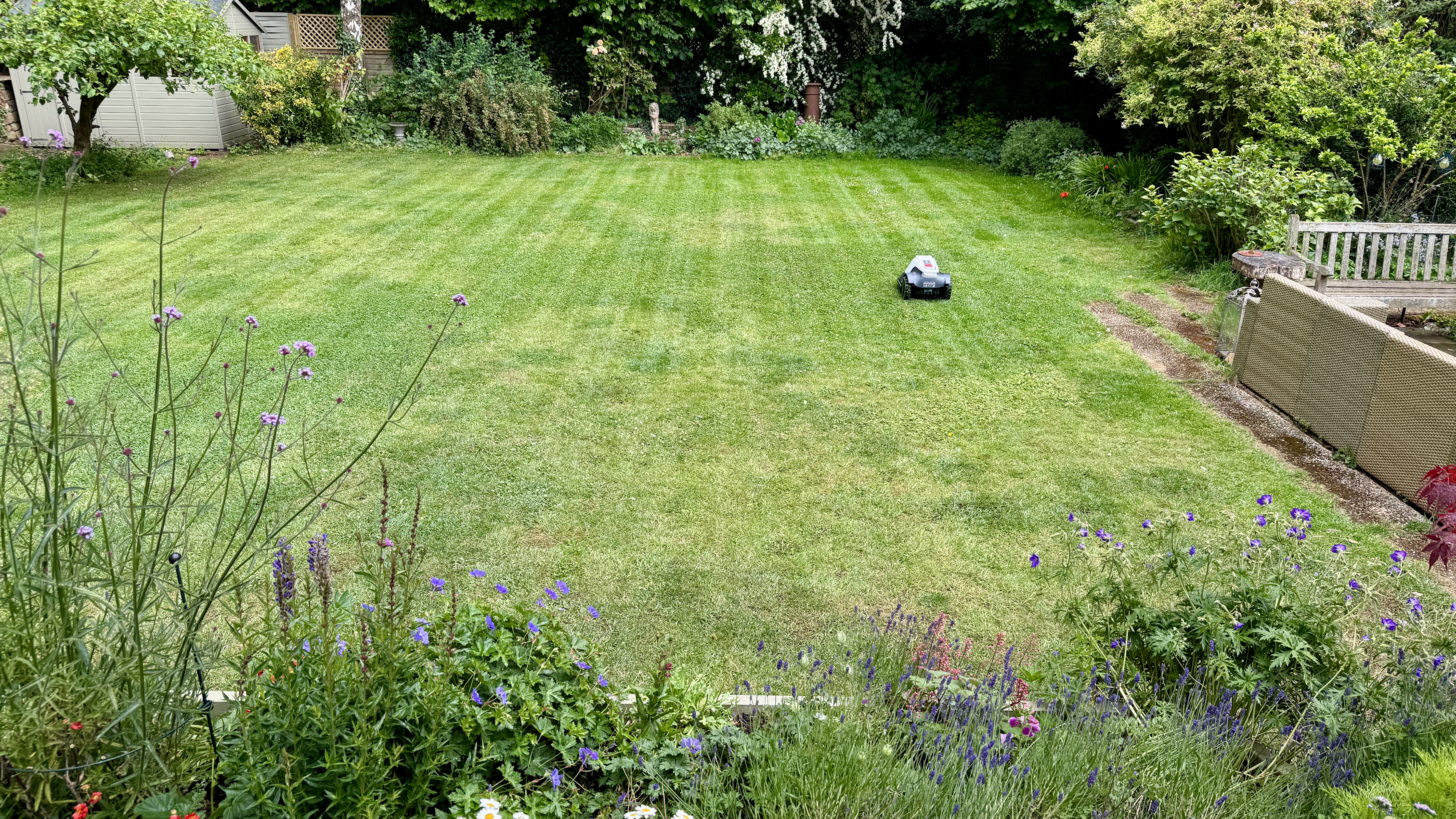 Eufy E15 robot lawn mower mowing neat stripes in reviewer's lawn