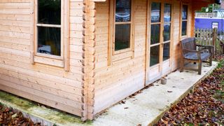 Untreated wooden summerhouse on concrete base