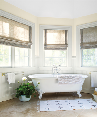 A bathroom with a freestanding tub and cream wall detailing.