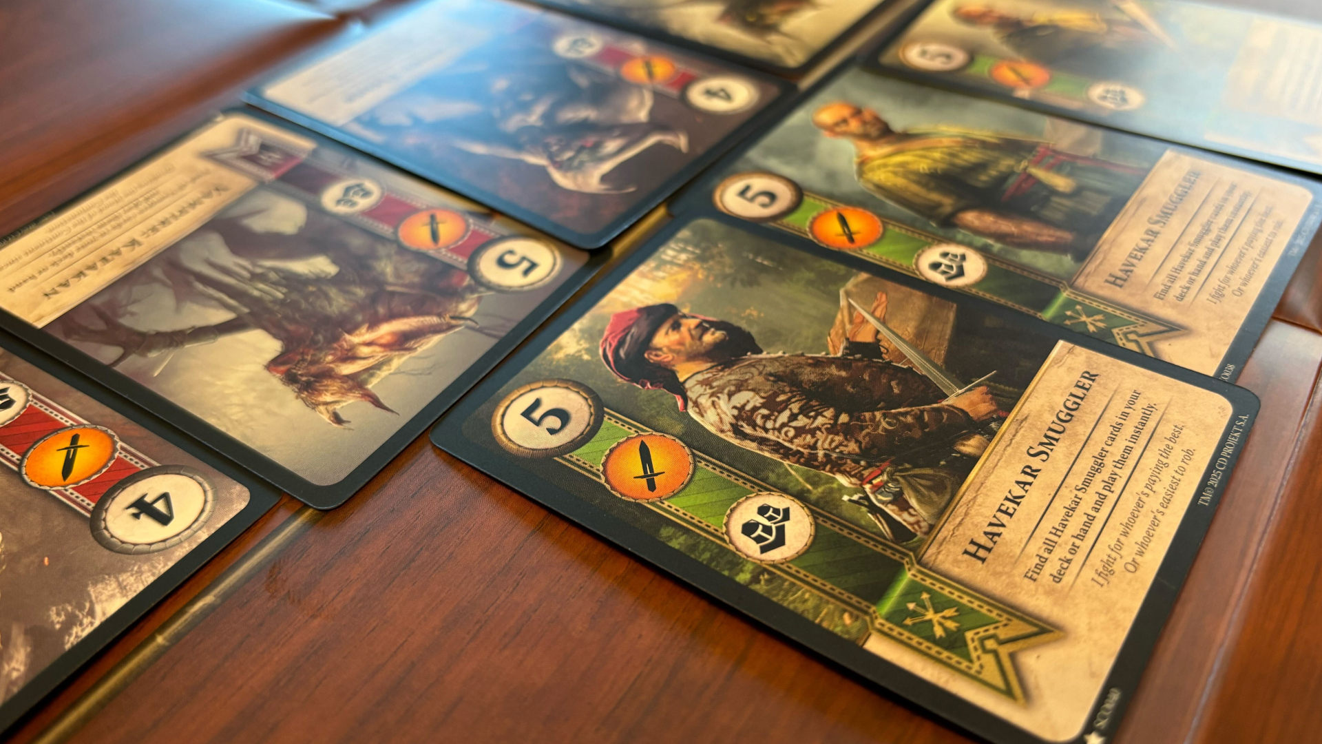 An assortment of Gwent cards lined up against a wood-effect surface