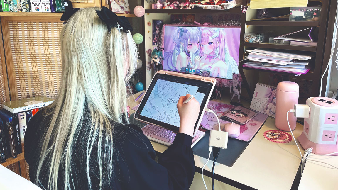 Artist in Residence; a woman sits at a desk drawing on an iPad Pro