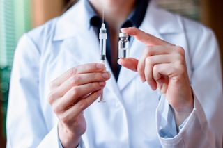 A healthcare provider holding a vaccine.