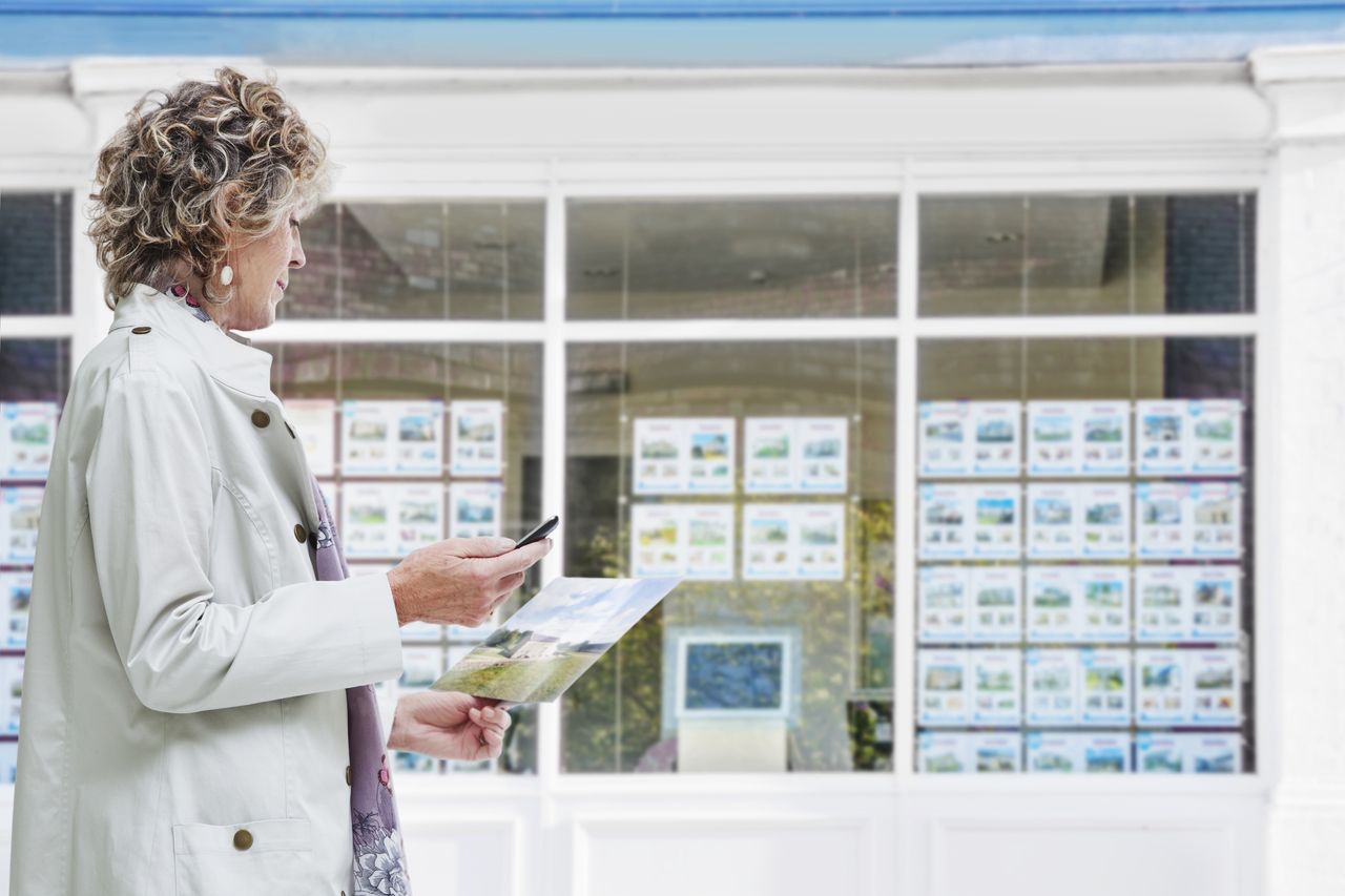 person outside estate agent window