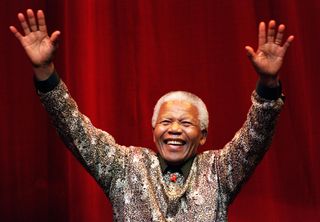 Nelson Mandela waves to the crowd after speaking at the Colonial Stadium for the World Reconciliation Day Concert September 8, 2000