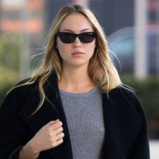 Lila Grace Moss wears a black coat with a gray shirt