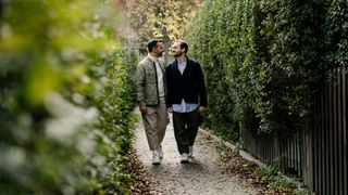 two men walking hand in hand in a park