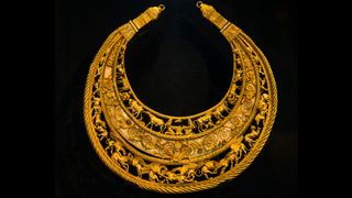 The famous ancient golden Scythian breast pectiral (necklace) on a black background, it depicts the animal world of southern Ukraine and the life of ancient Scythians.