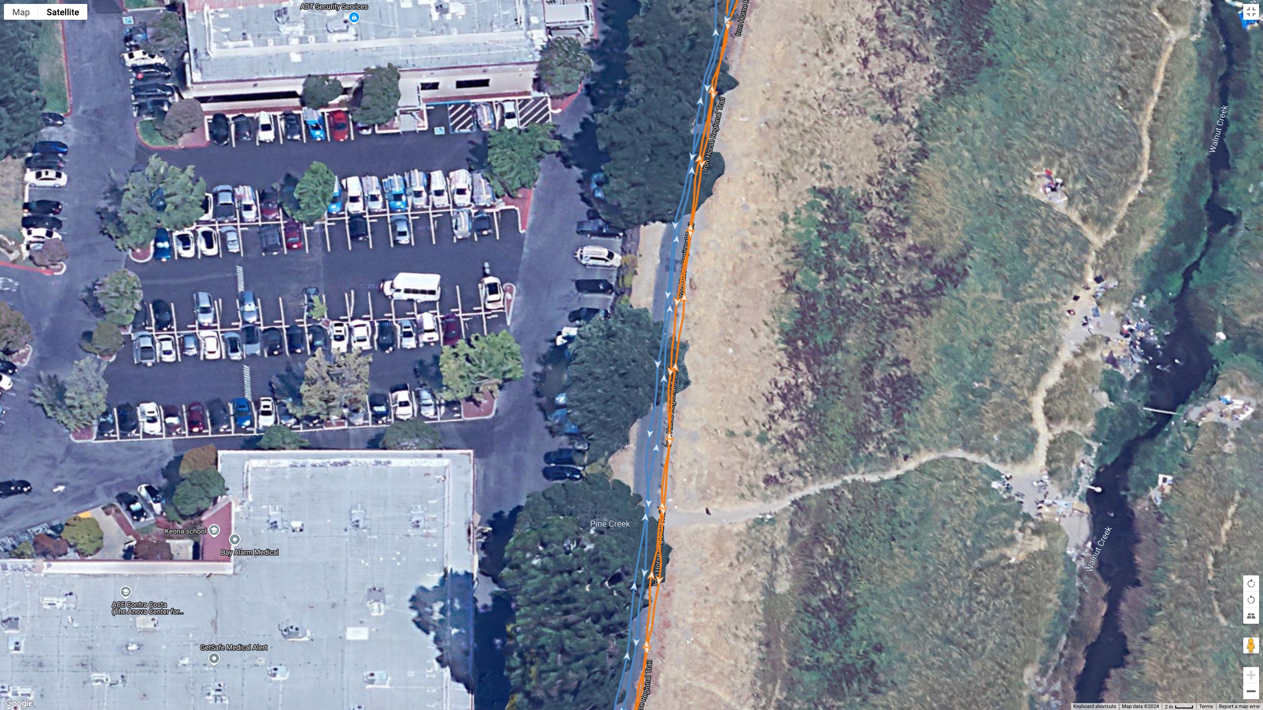 A Google Maps satellite view showing how the Polar Vantage M3 (orange line) and Garmin Fenix 8 (blue line) compared for GPS accuracy during a run.