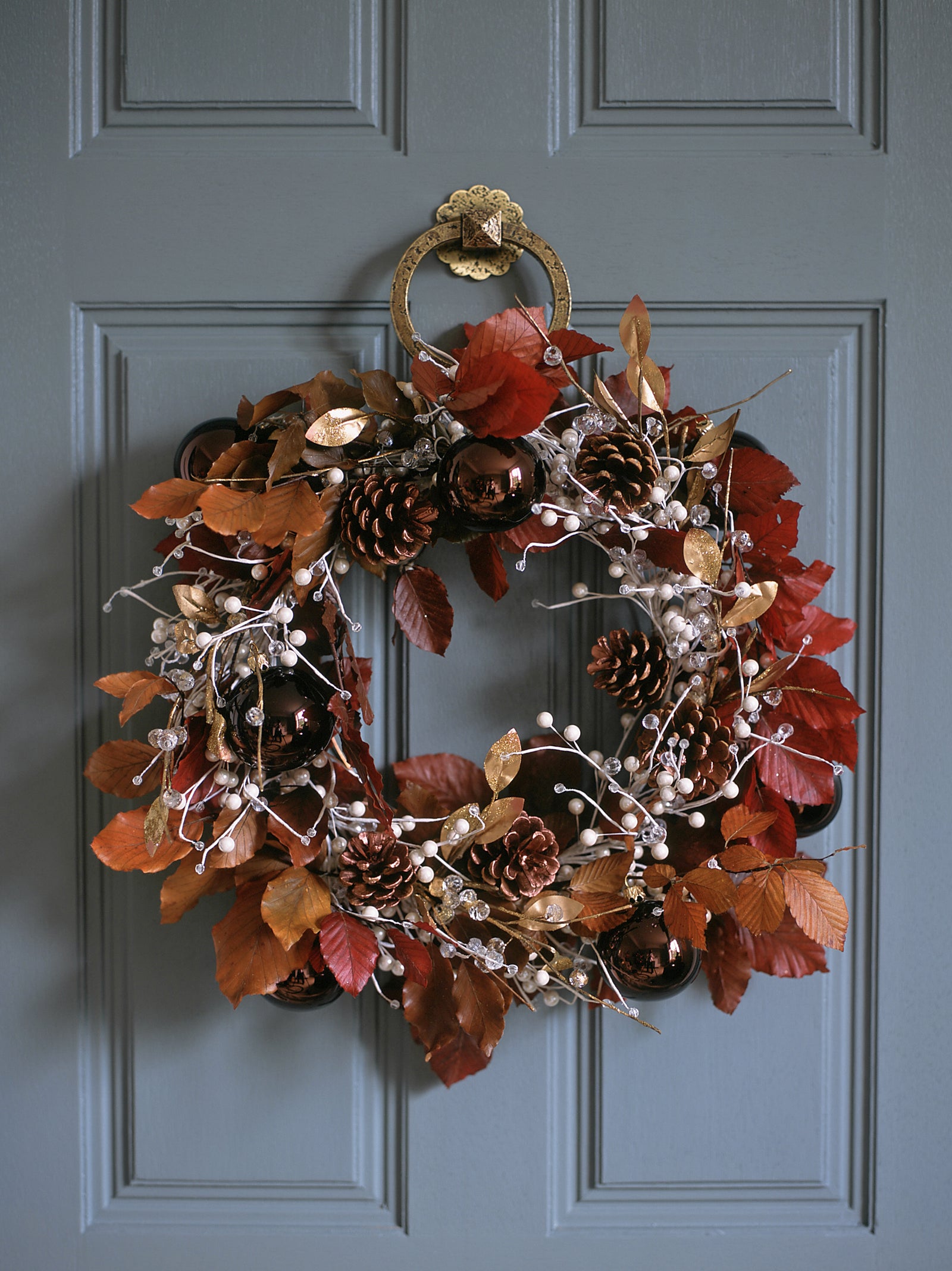 Leaf wreath with pine cones, berries, gold leaves, and baubles