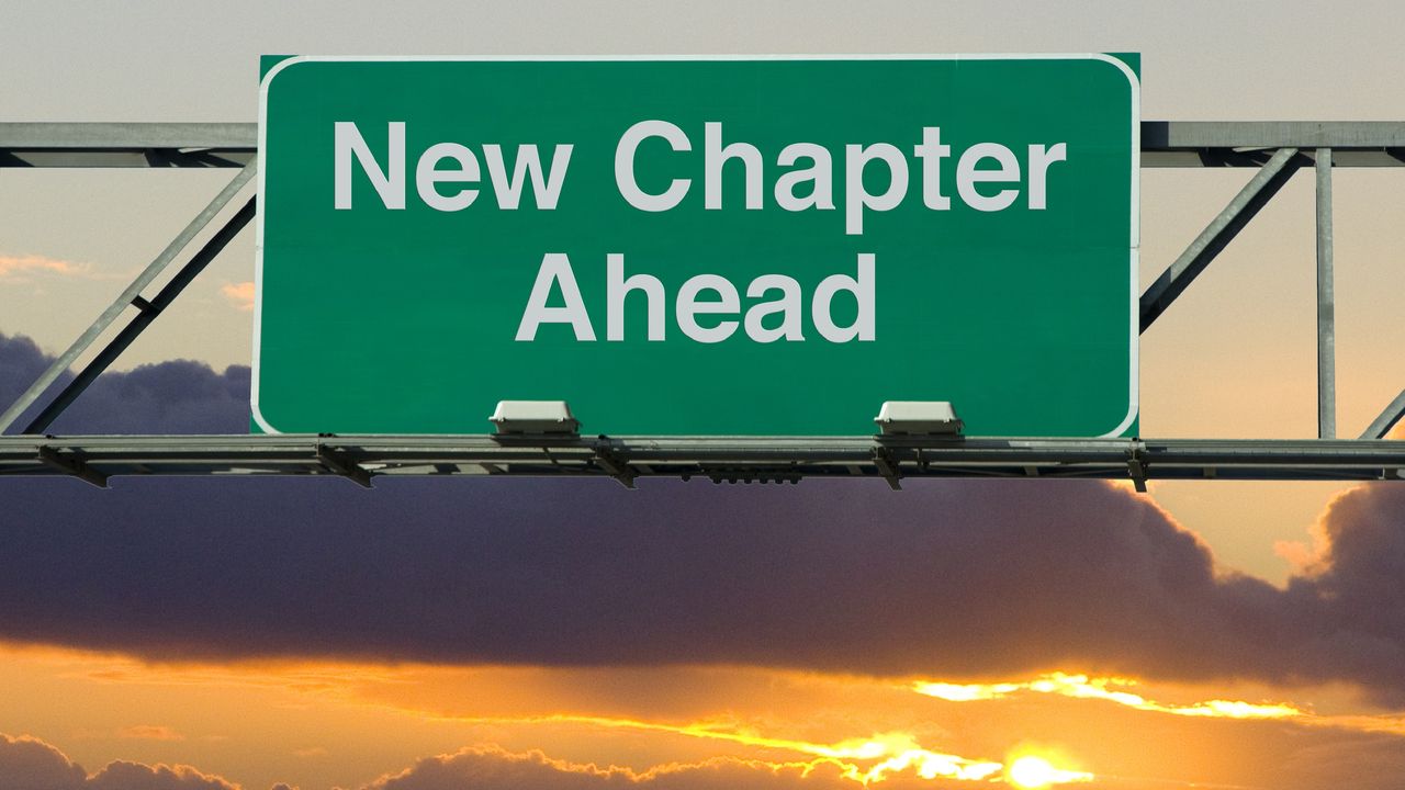 A road sign says &quot;New Chapter Ahead,&quot; set against a pretty sunset.