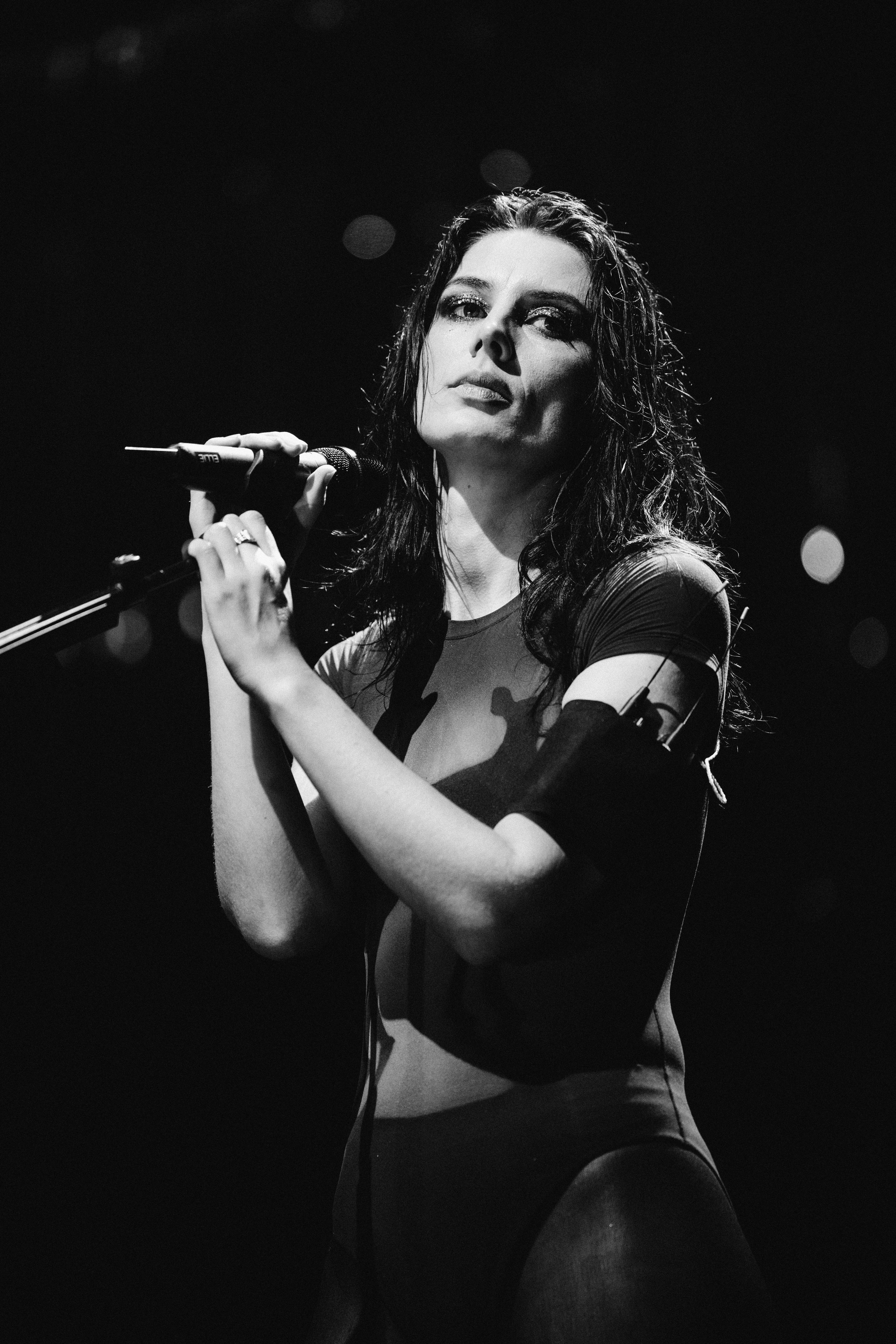 ellie rowsell of wolf alice performing on stage at a microphone wearing hot shorts and a sheer top