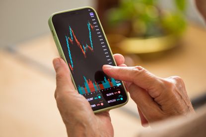 Woman using phone to check stock market activity