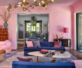 living room with barbie pink walls and blue sofas view to hall