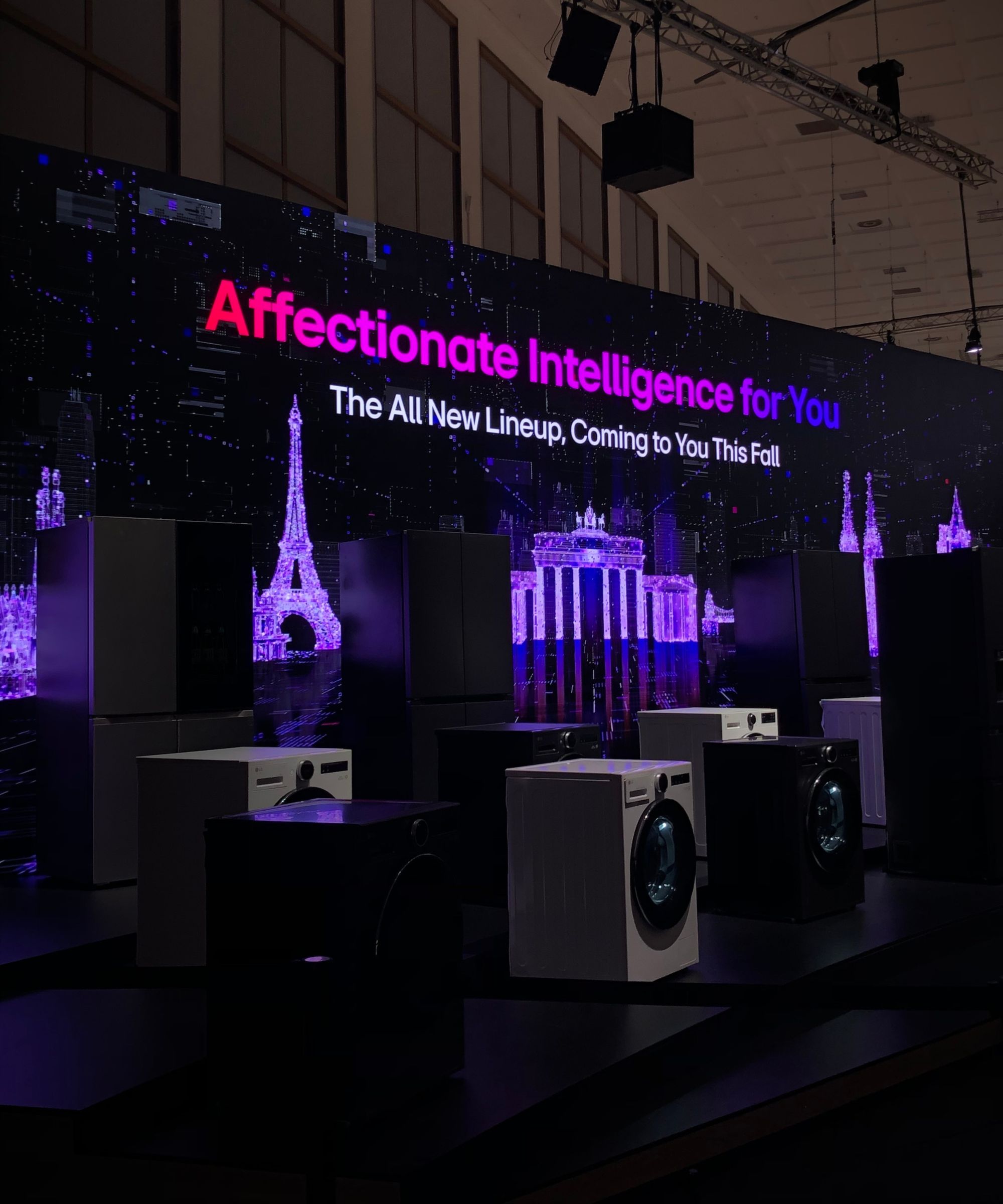 Screen showing &#039;Affection Intelligence for You&#039; during demonstration of LG&#039;s AI appliances at IFA Berlin 2025, with a row of washing machines, dryers and fridge freezers pictured in foreground.