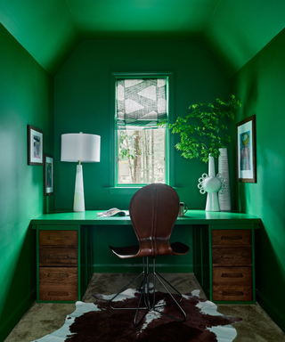 Emerald office space with cowhide rug and white table lamp