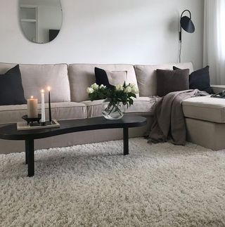 Black coffee table on beige rug