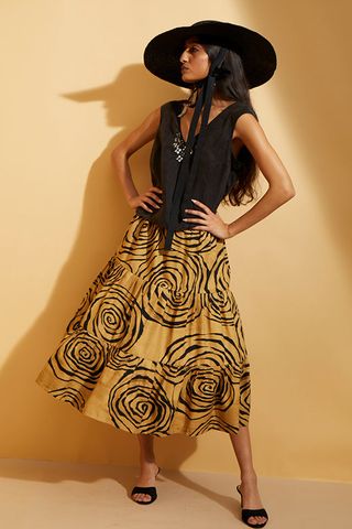 A model wearing a black corset top and yellow and black swirl print skirt Hope for Flowers by Tracy Reese