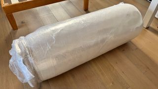 The Birch Natural Mattress rolled up in plastic