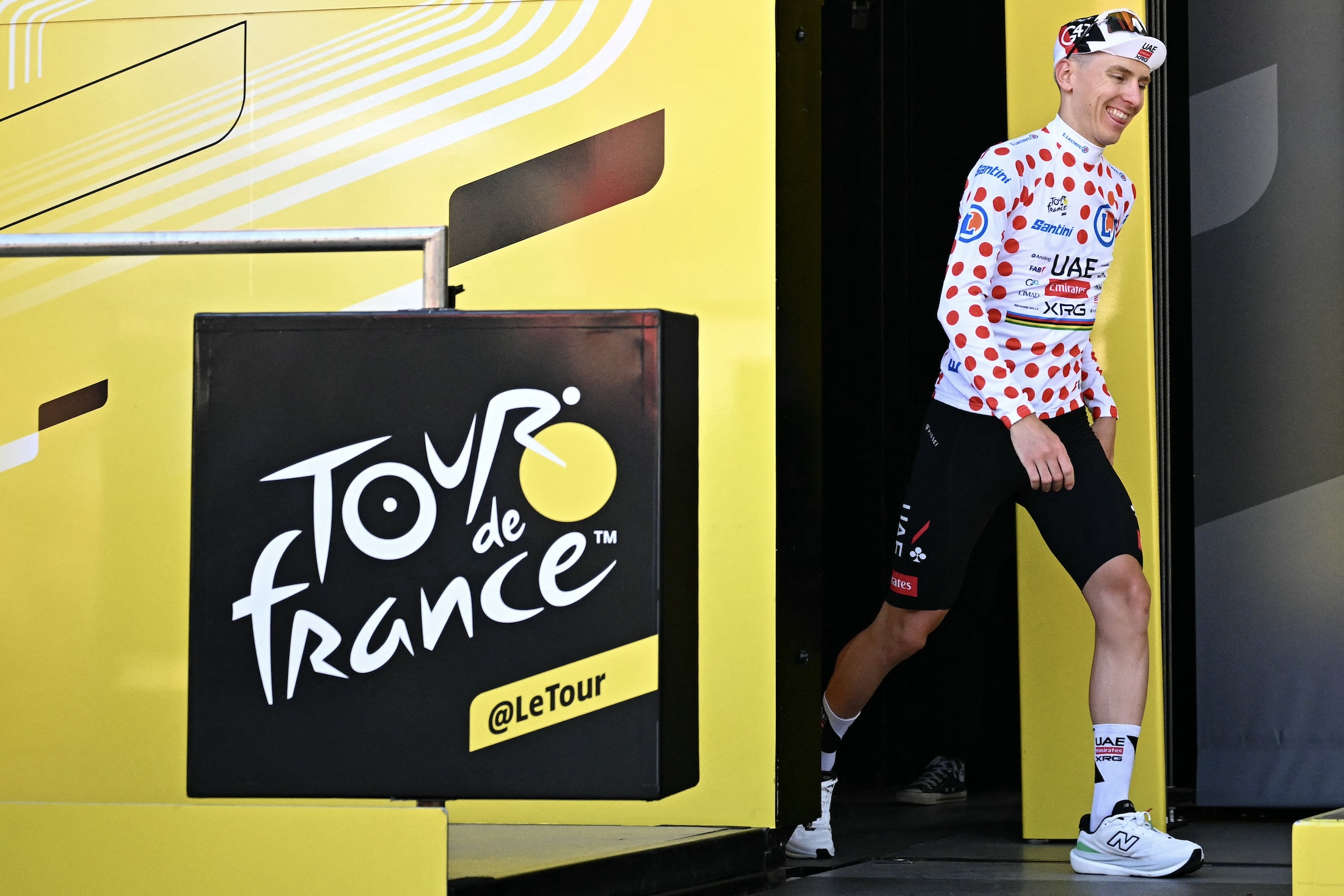 Tadej Pogacar walks onto the podium wearing the polka dot jersey of best climber after stage 1 of the 2026 Tour de France