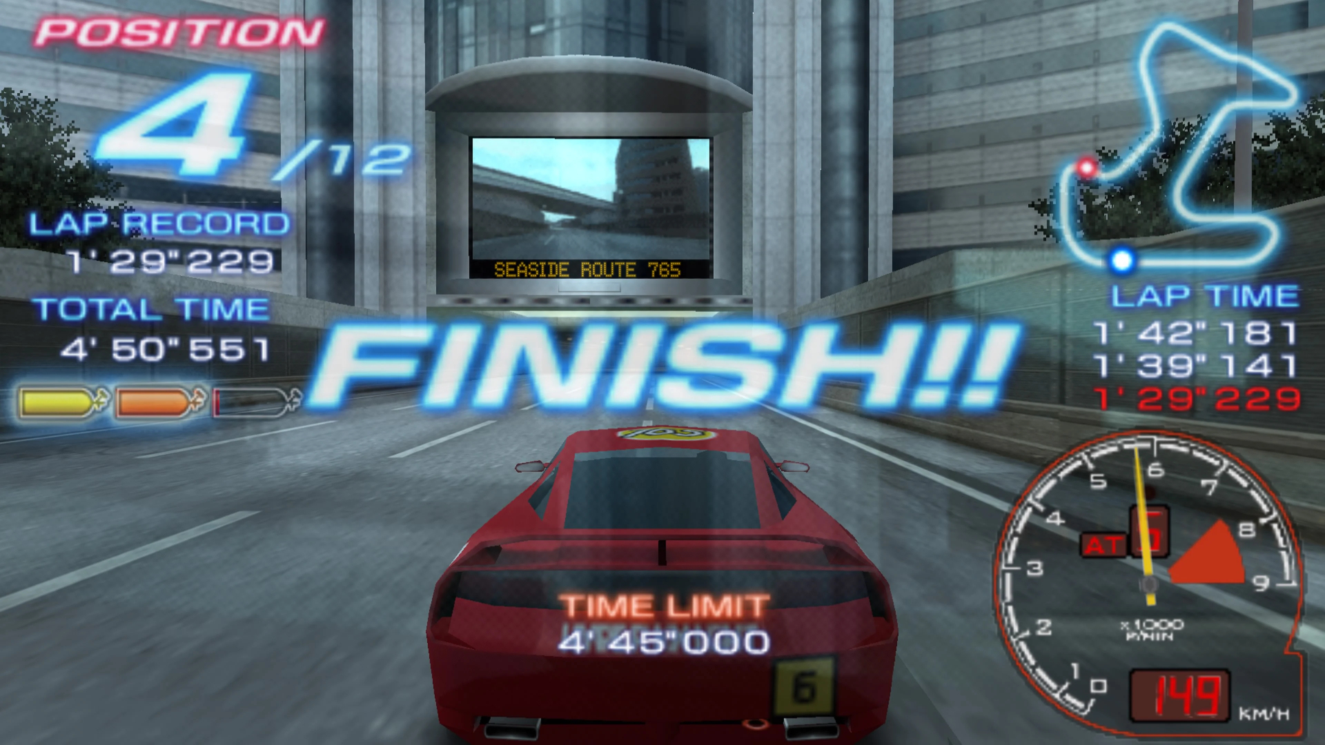 A race car crosses the finish line at a city track in Ridge Racer 2