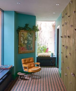 basement hall with turquoise walls, leather swivel chair and climbing wall