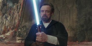 Luke Skywalker holding blue lightsaber in Star Wars: The Last Jedi