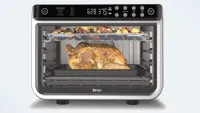 Ninja Foodi 10-in-1 XL Pro Air Fry Oven DT201 roasting a turkey inside and roast vegetables at the top rack