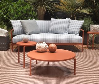 orange outdoor table with a grey sofa