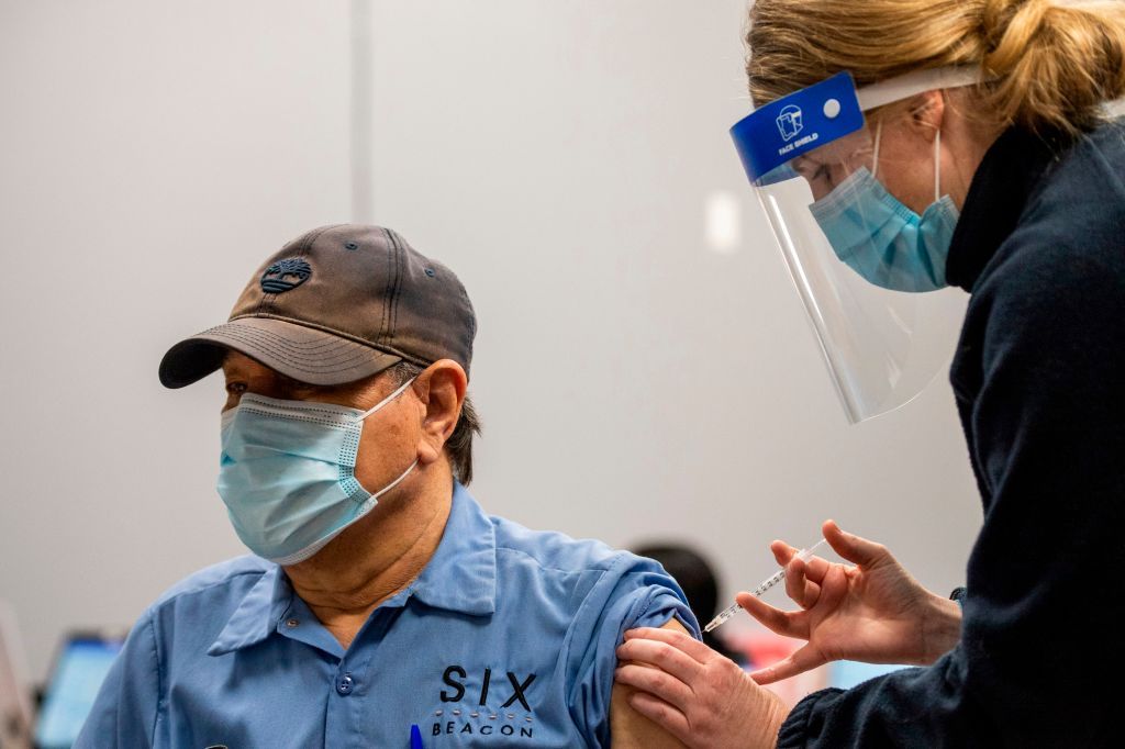 Jesus Rivera is inoculated with the Pfizer-BioNTech Covid-19 vaccine by Nurse Practitioner Kathleen Klein at La Colaborativa in Chelsea, Massachusetts