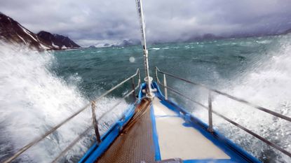 Closeup of bow on expedition yacht navigating through rough waters