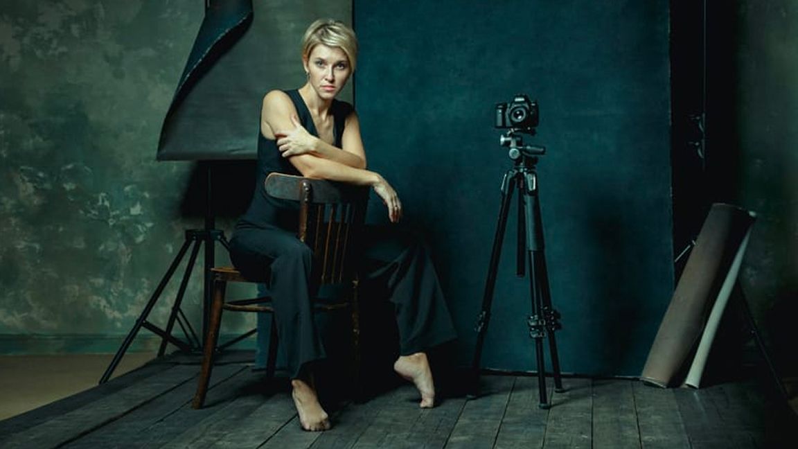 NFT photography; a photo of a woman with a camera in a dark room