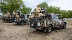 Nigerian soldiers from the Multinational Joint Task Force (MNJTF) sit on parked vehicles during training at the MNJTF military base, Sector 3 Headquarters, in Monguno, Borno state, Nigeria, on July 5, 2025. Twelve checkpoints manned by the Nigerian army control the various entrances to Monguno. Monguno's huge fortifications have kept the garrison town mostly secure even as northeastern Nigeria has seen a recent surge in attacks on military bases by jihadists fighting a grinding 16 year war. Fighting in Borno may have eased since the conflict's highpoint in 2015 as jihadists have been forced back. But militants from Islamic State West Africa Province or rival Boko Haram have attacked or temporarily overrun a dozen military bases since the start of the year. (Photo by Joris Bolomey / AFP) (Photo by JORIS BOLOMEY/AFP via Getty Images)
