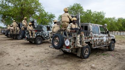 Nigerian soldiers from the Multinational Joint Task Force (MNJTF) sit on parked vehicles during training at the MNJTF military base, Sector 3 Headquarters, in Monguno, Borno state, Nigeria, on July 5, 2025. Twelve checkpoints manned by the Nigerian army control the various entrances to Monguno. Monguno's huge fortifications have kept the garrison town mostly secure even as northeastern Nigeria has seen a recent surge in attacks on military bases by jihadists fighting a grinding 16 year war. Fighting in Borno may have eased since the conflict's highpoint in 2015 as jihadists have been forced back. But militants from Islamic State West Africa Province or rival Boko Haram have attacked or temporarily overrun a dozen military bases since the start of the year. (Photo by Joris Bolomey / AFP) (Photo by JORIS BOLOMEY/AFP via Getty Images)