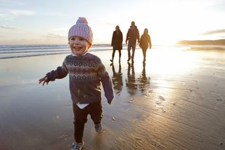 Family walking on a beach at sunset