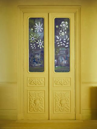 yellow painted closet doors, ornate detailing, painted glass with pots and flowers