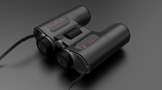 Unistellar Envision smart binoculars laid flat on a gray background