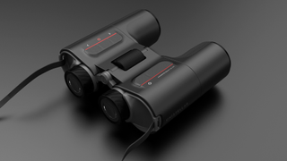Unistellar Envision smart binoculars laid flat on a gray background
