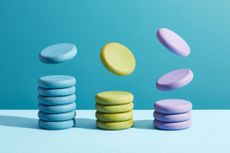 Three stacks of coloured coins representing exchange-traded fund flows