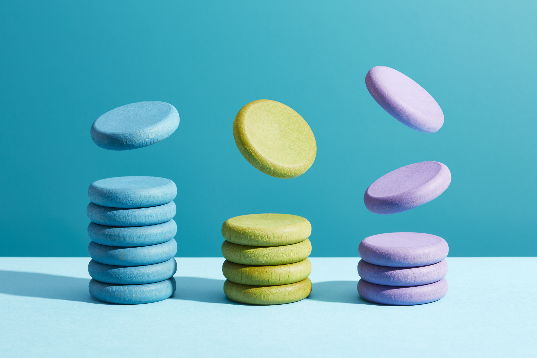 Three stacks of coloured coins representing exchange-traded fund flows