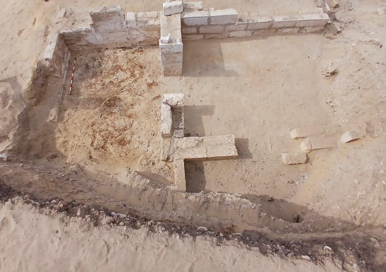 A bird-eye's view of a cemetery with a stone wall in the desert