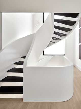White curved staircase with black steps