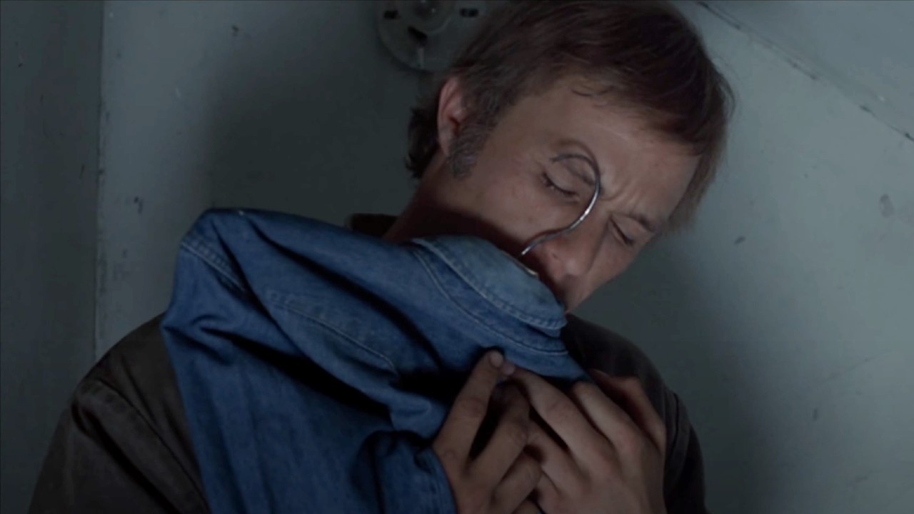 Ennis hugging a jacket that's on his hanger.