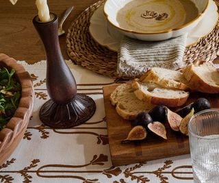 Magnolia dining room set up with crockery on the table and a vase of faux flowers in the middle