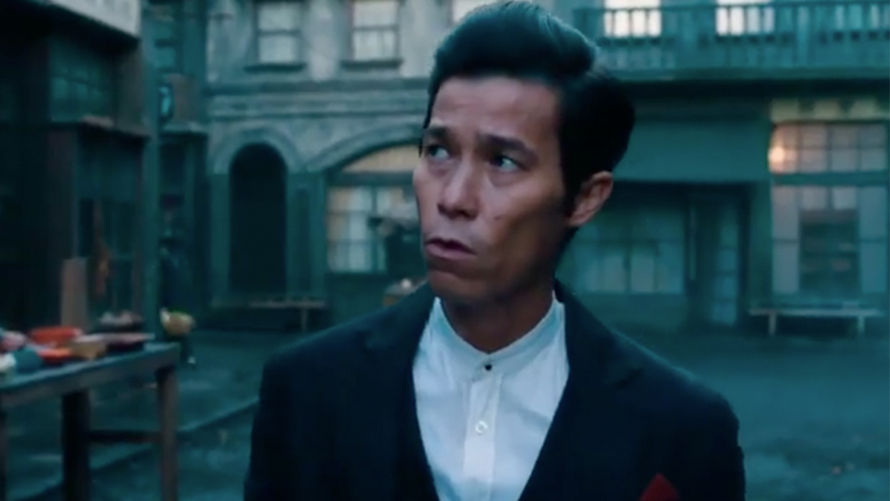 Jason Tobin in a suit, walking in a street in Warrior