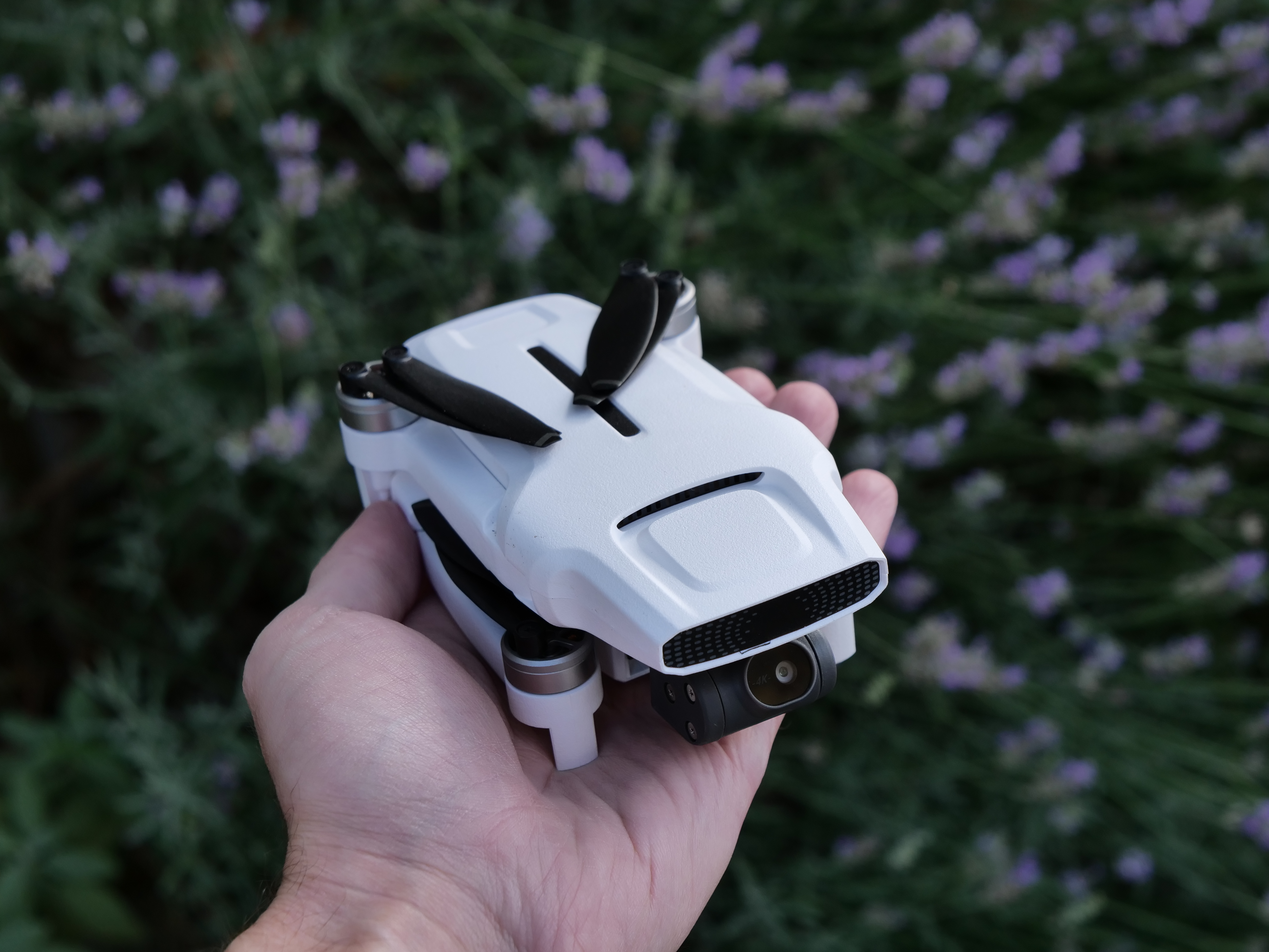 A hand holding the folded FIMI X8 Mini drone