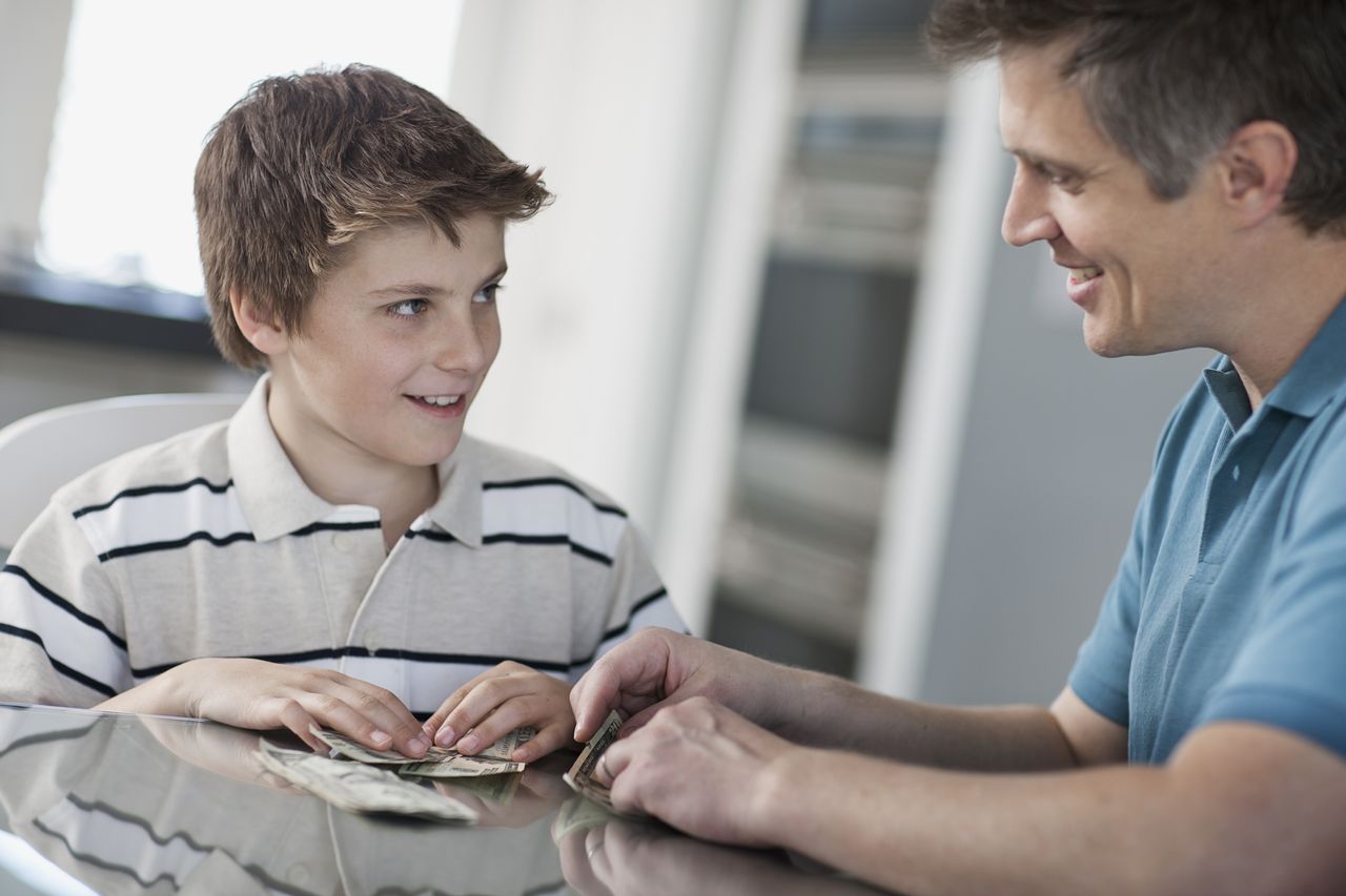 A boy and his father count money.