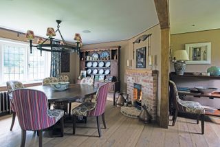 diningroom with wooden floor and a lit fireplace